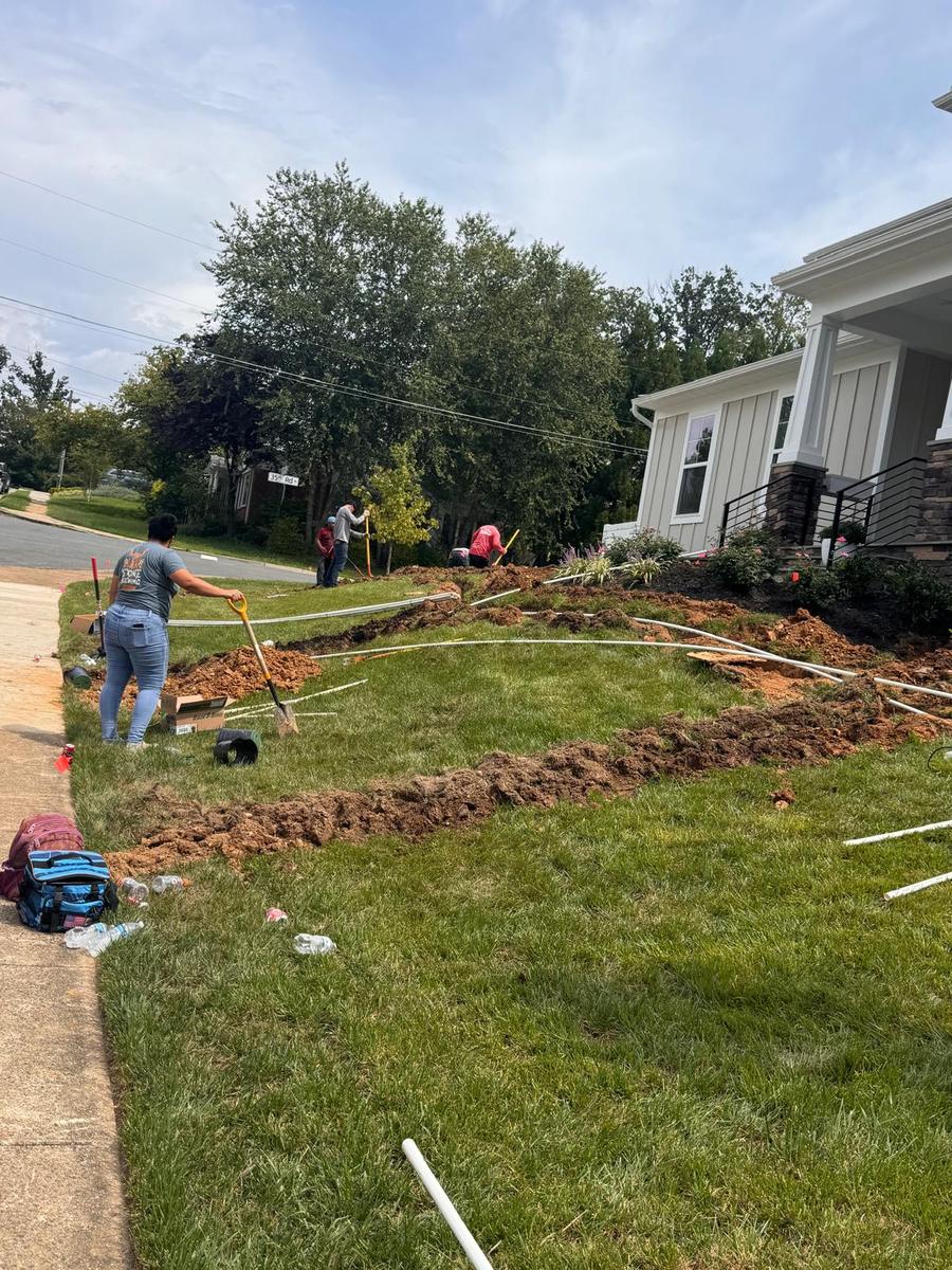 Wider view of the front-yard trench curving toward the entrance
