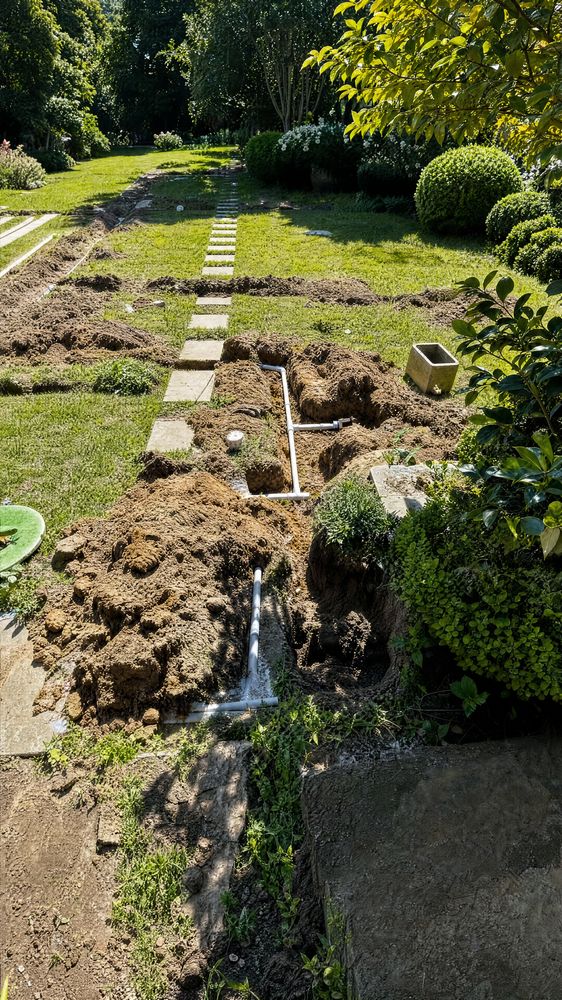 Aerial view of the crew trenching a lawn beside two Two Brothers Sprinkler service trucks